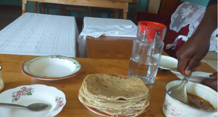Ein Tisch gedeckt mit Tellern, Teigfladen und einem Topf gefüllt mit Soße