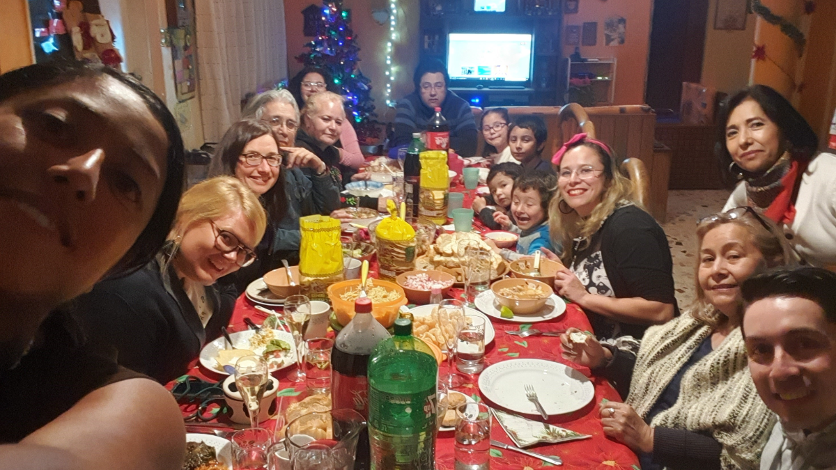 Kristy Peña mit ihrer Familie sitzend an einem großen Tisch beim Weihnachtsessen.